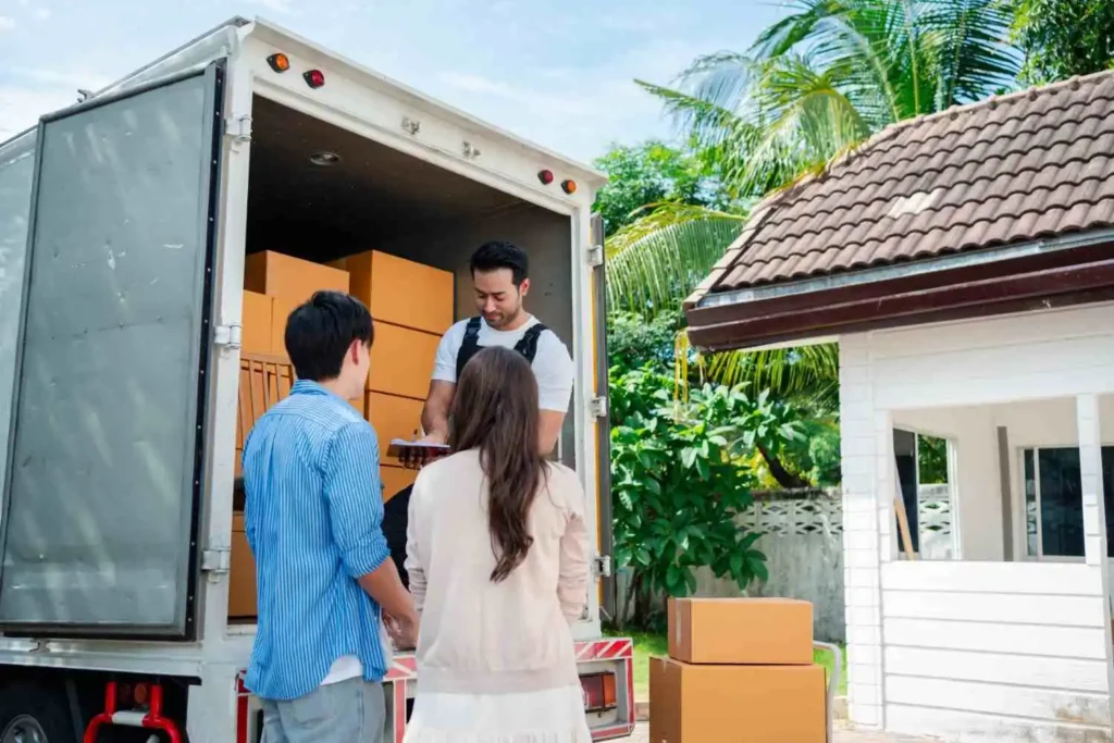 Englewood FL movers loading wrapped furniture into a moving truck outside a Gulf Coast ranch home