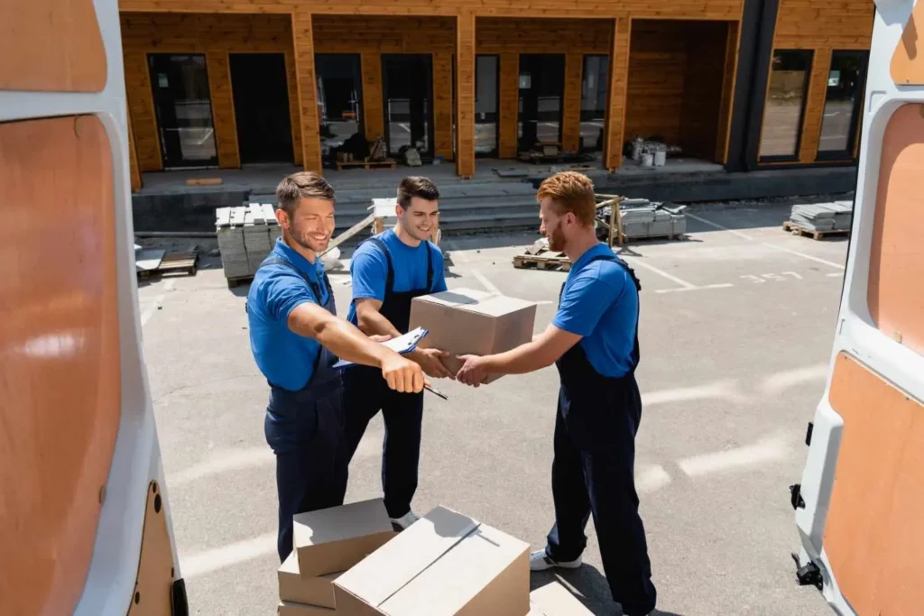 Moving companies long distance Florida — Moving Hub in-house crew loading a branded carrier truck outside a Fort Lauderdale home