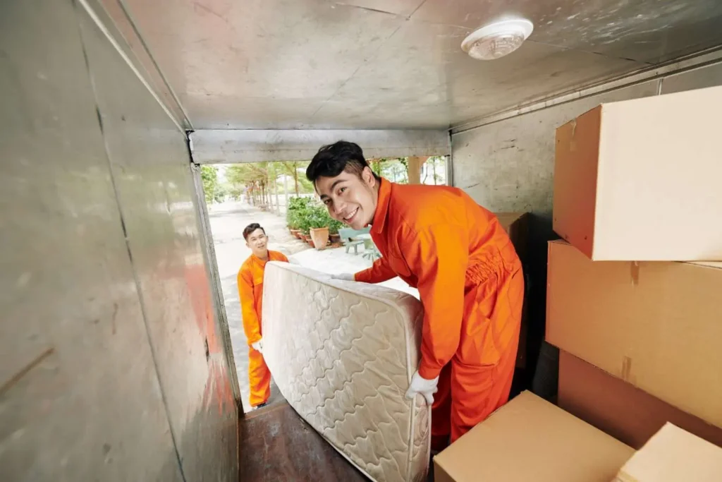 Moving Hub vs Allied Van Lines comparison showing a moving crew loading wrapped furniture into a truck